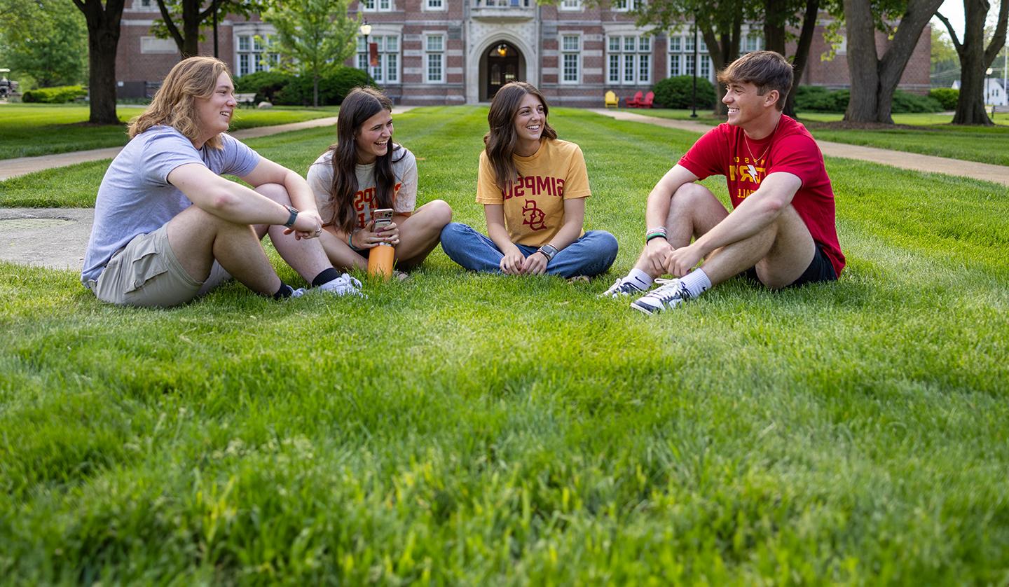 Students sitting in 的 quad laughing